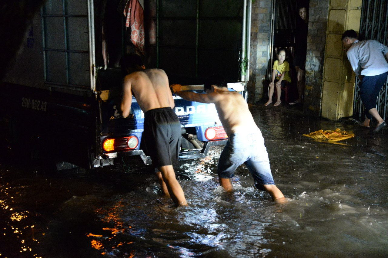 Người Hà Nội đẩy ôtô, dắt xe máy trong cơn mưa tầm tã nhiều giờ