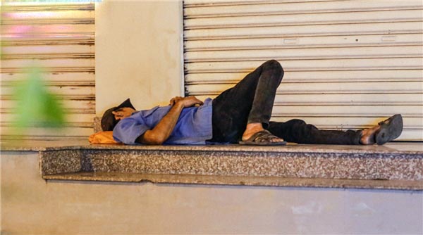 Giấc ngủ tạm bợ bên một mái hiên của một thanh niên bán vé số.