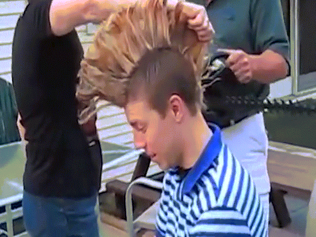 Dùng cưa máy để cắt tóc cho con trai
