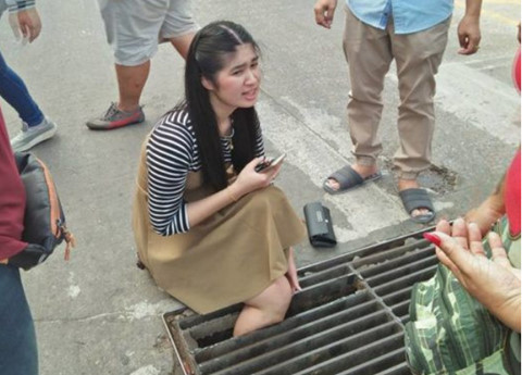Cô gái Thái Lan kẹt chân dưới cống vì mải dùng điện thoại