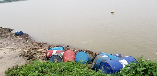 Hàng chục thùng phuy nghi chứa hóa chất bị đổ xuống sông Hồng