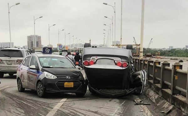 Ôtô Honda Civic lật ngửa trên cầu Vĩnh Tuy sau va chạm với xe taxi