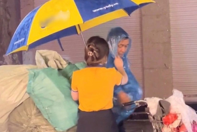Cô gái tặng áo mưa, che ô cho cụ ông nhặt ve chai giữa mưa lớn