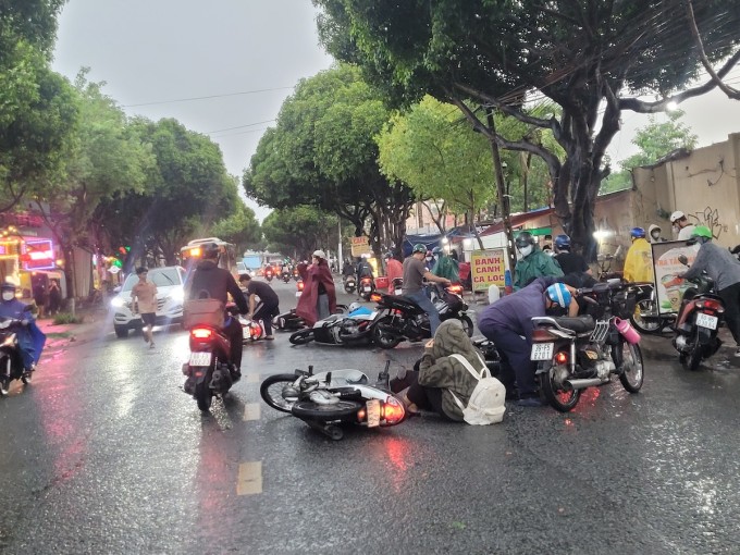 Hàng loạt xe máy trượt ngã trong mưa